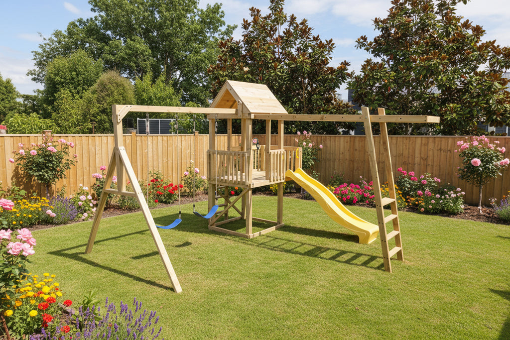Wooden playground set with a slide and swings on grass, surrounded by trees and a fence.